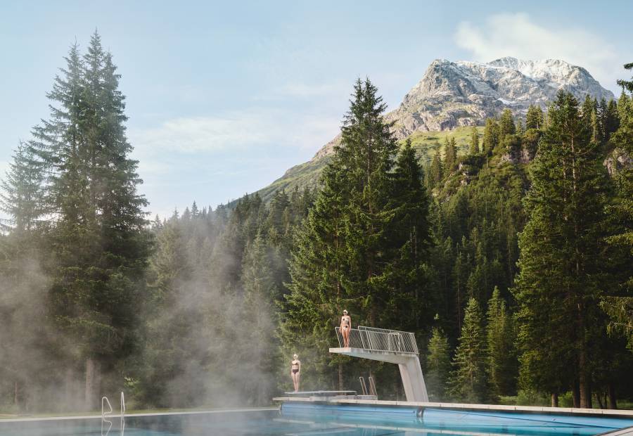 Sprungturm im Waldschwimmbad mit Ausblick auf die Berge