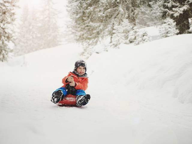 Schlitten fahren Winterurlaub mit Kindern